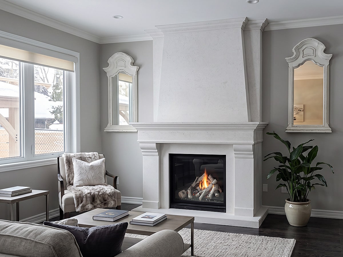 Custom cast stone mantel installation by Omega Mantels