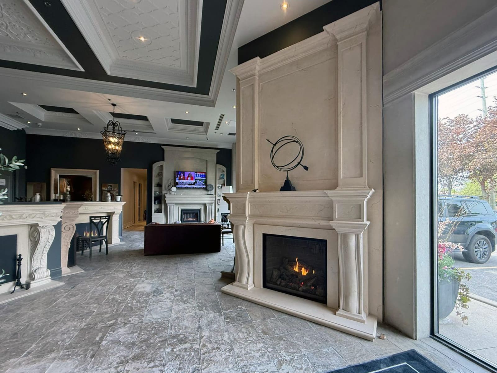 Gas fireplace with custom cast stone mantel on display at Omega Flames showroom