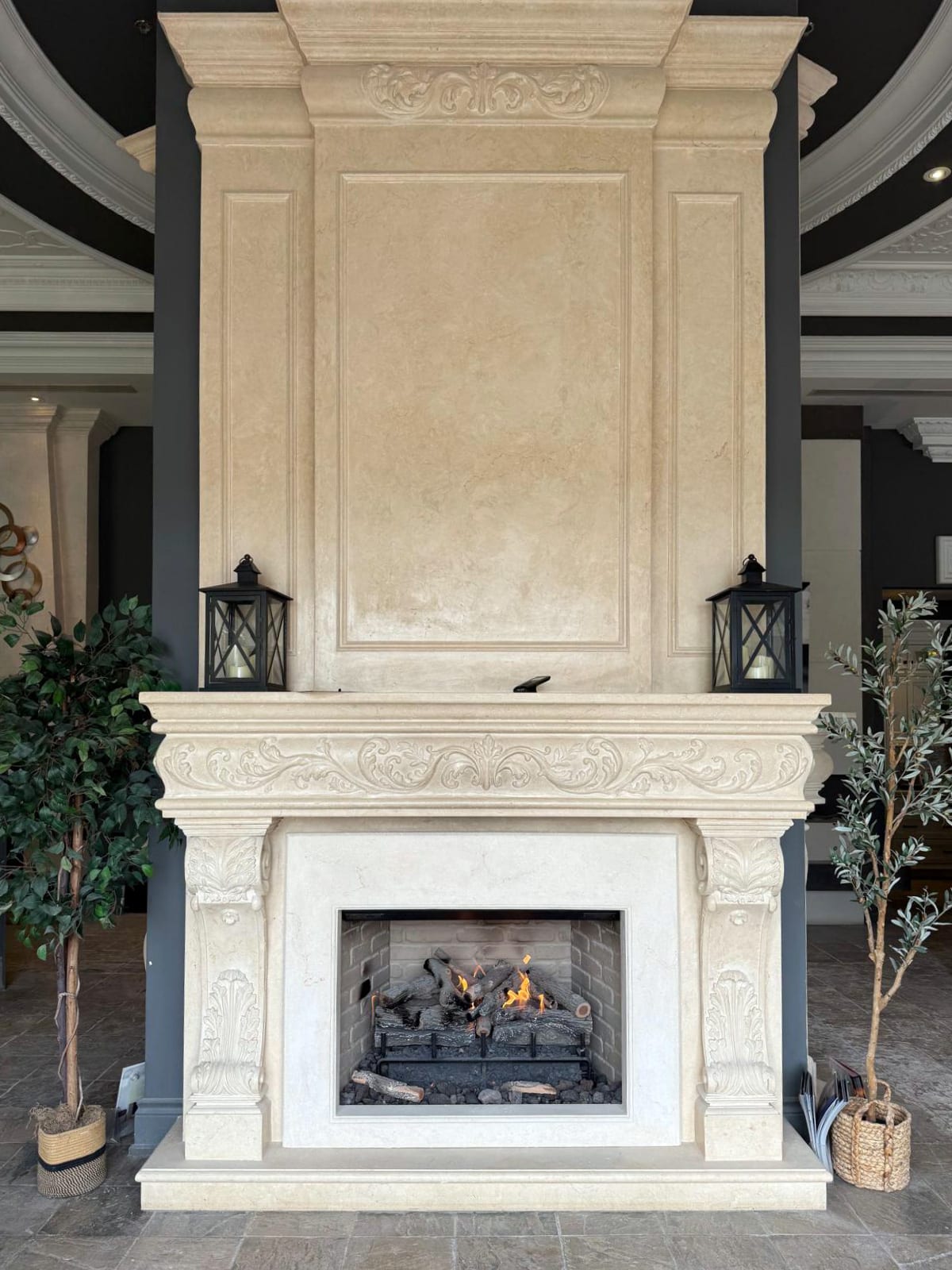 Traditional fireplace with ornate cast stone surround at Omega Flames showroom